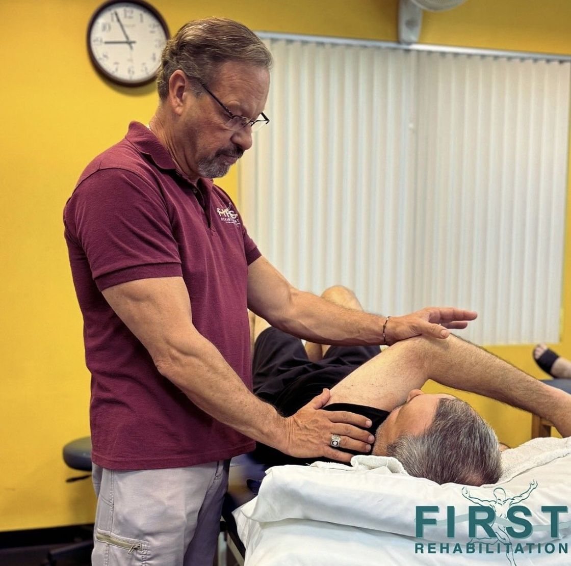 Dr. Dave Kashuba, Occupational Therapist, stretching a patient's leg during a session at First Rehabilitation in North Palm Beach